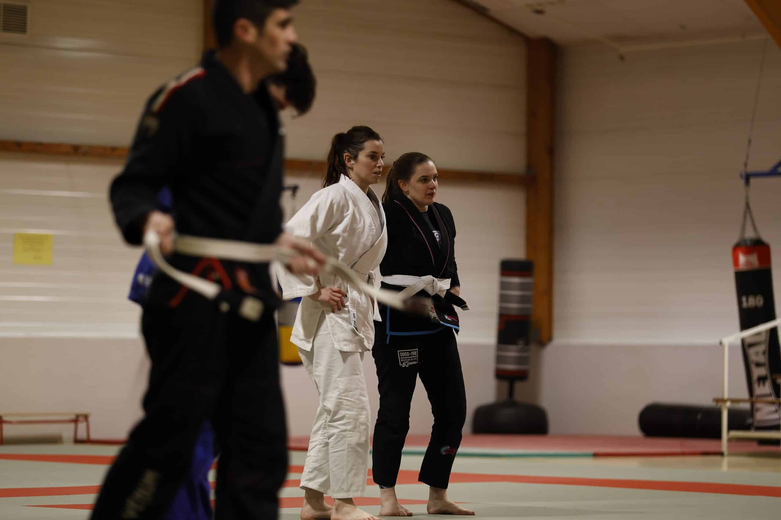 Lors d'un cours mixte de Jiu-Jitsu Brésilien à Vannes – Alicia et Elfie attentives aux explications techniques pendant un entraînement adulte à la Skol Emgann