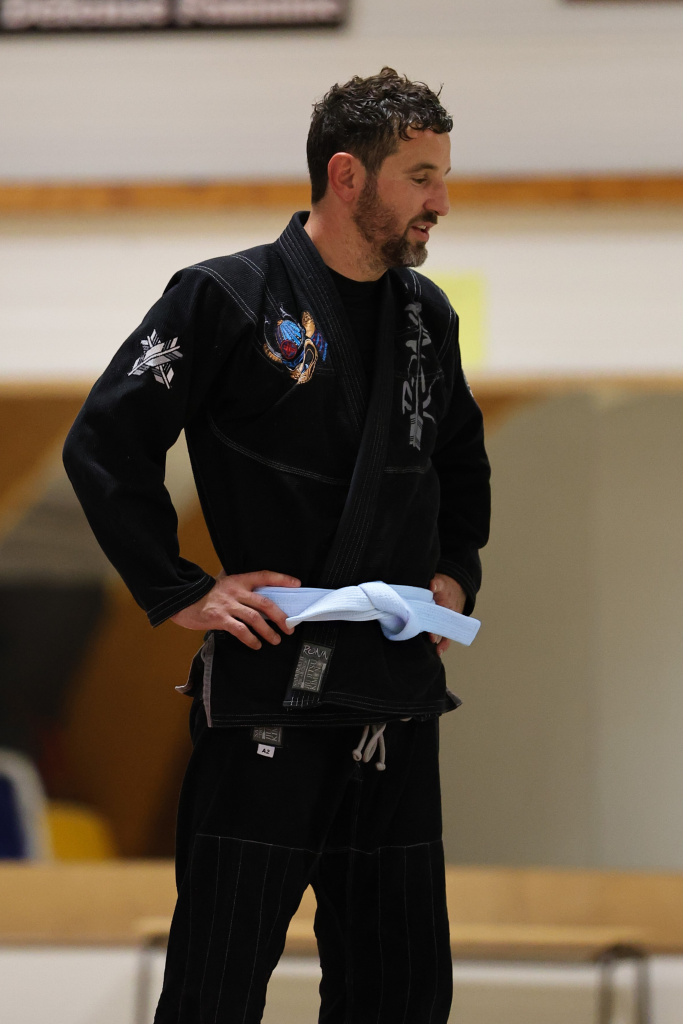 Clément Le Roux, membre bénévole du comité directeur de la Skol Emgann, en kimono noir, debout de profil lors d’un cours de jiu-jitsu brésilien à Vannes.