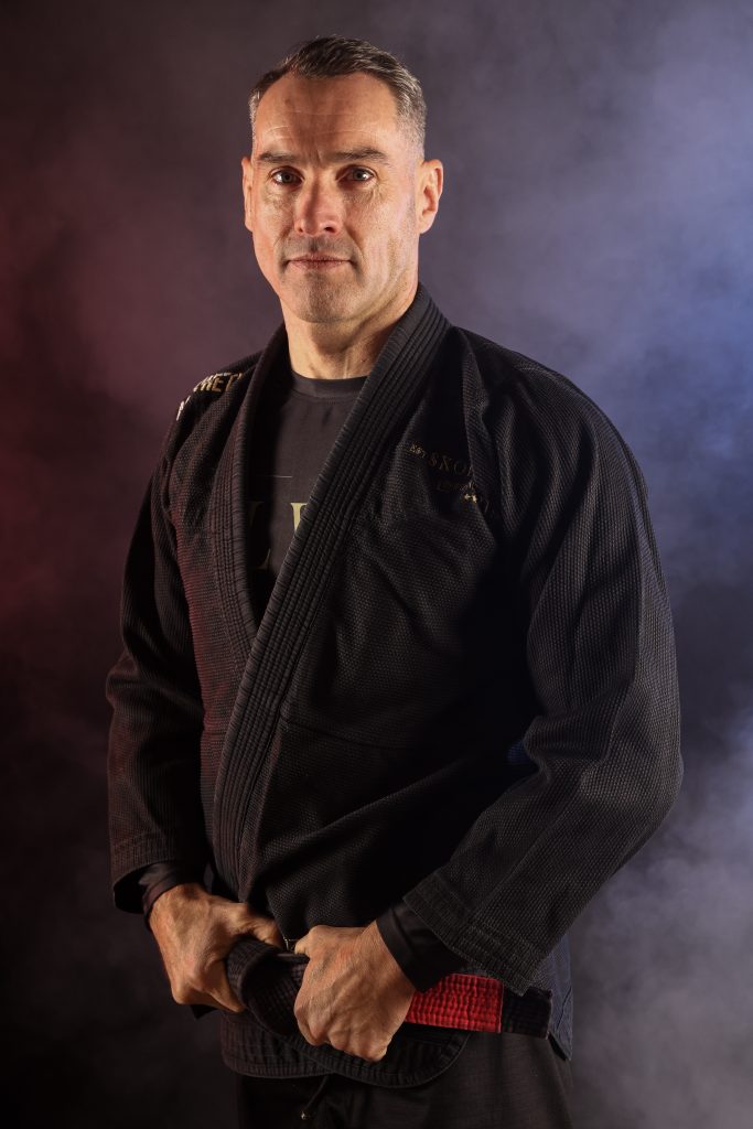 Portrait de Fabrice Le Mentec, ceinture noire de jiu-jitsu brésilien, en kimono noir, sur fond studio.