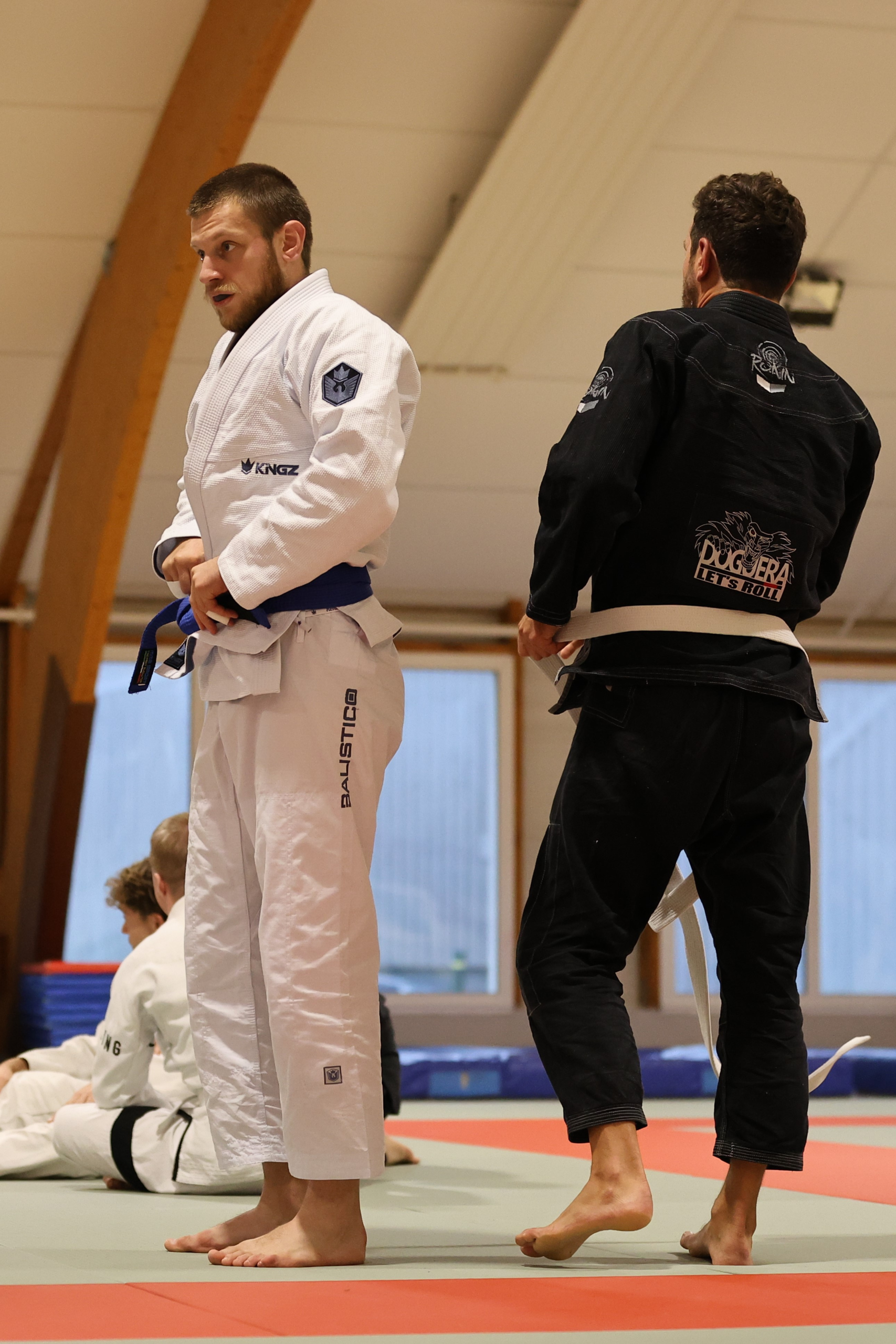 Deux pratiquants de jiu-jitsu brésilien debout sur le tatami à Vannes, en kimono blanc et noir, à l’issue d’un entraînement au club Skol Emgann.