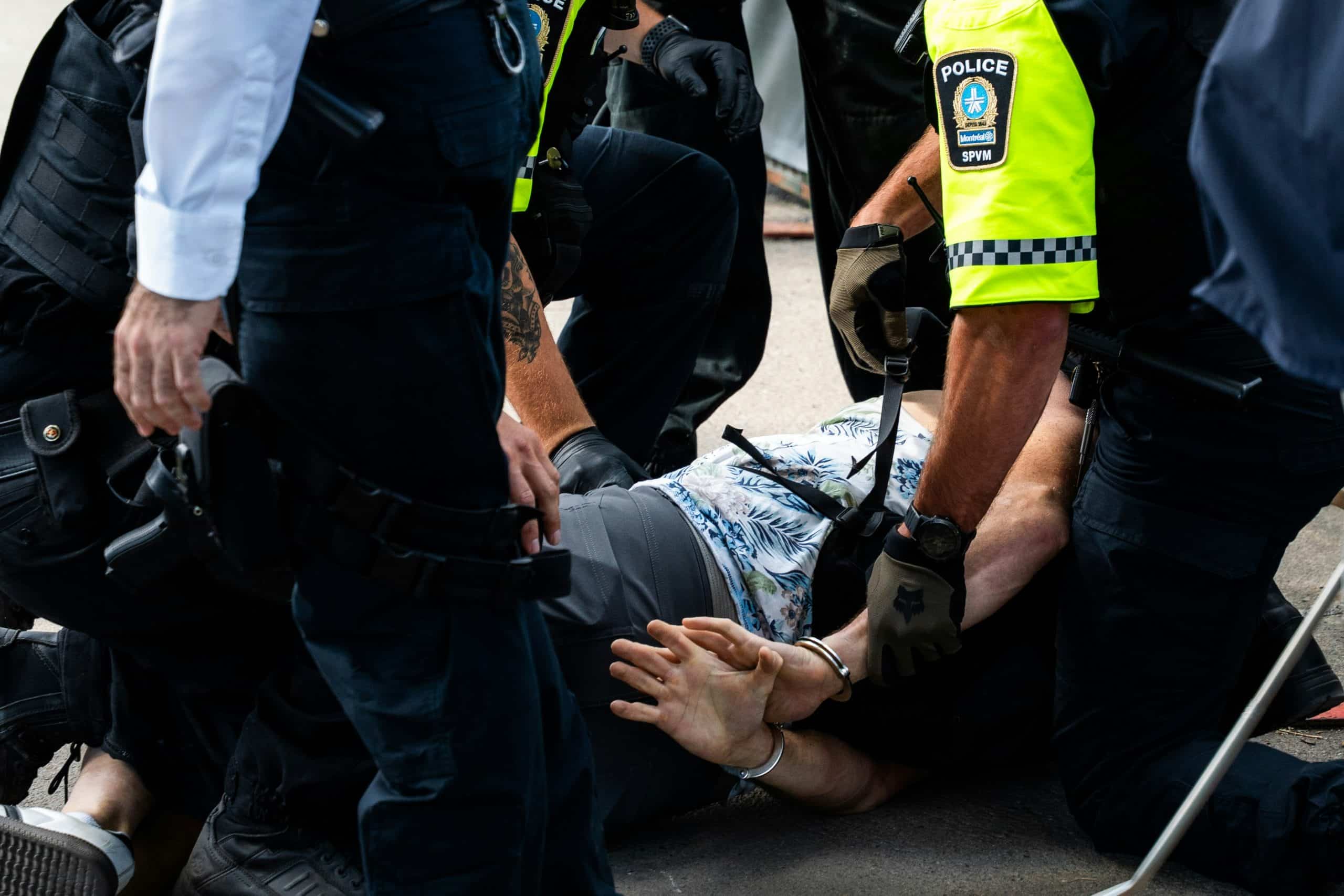 Interpellation au sol par des agents de police, illustrant une immobilisation contrôlée et sécurisée.