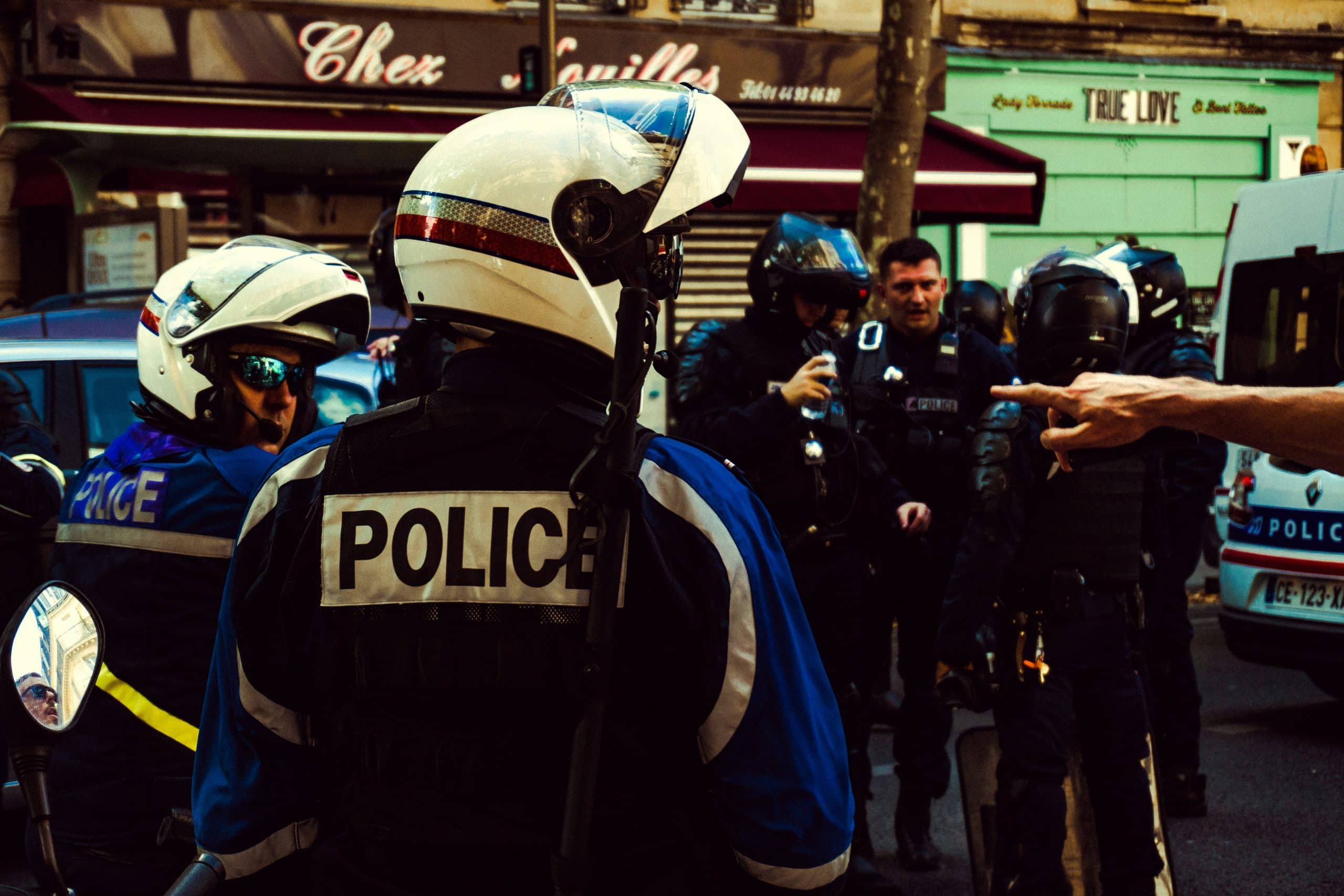 Policiers équipés intervenant en milieu urbain lors d’une situation de tension, illustrant la nécessité de maîtrise physique et émotionnelle.